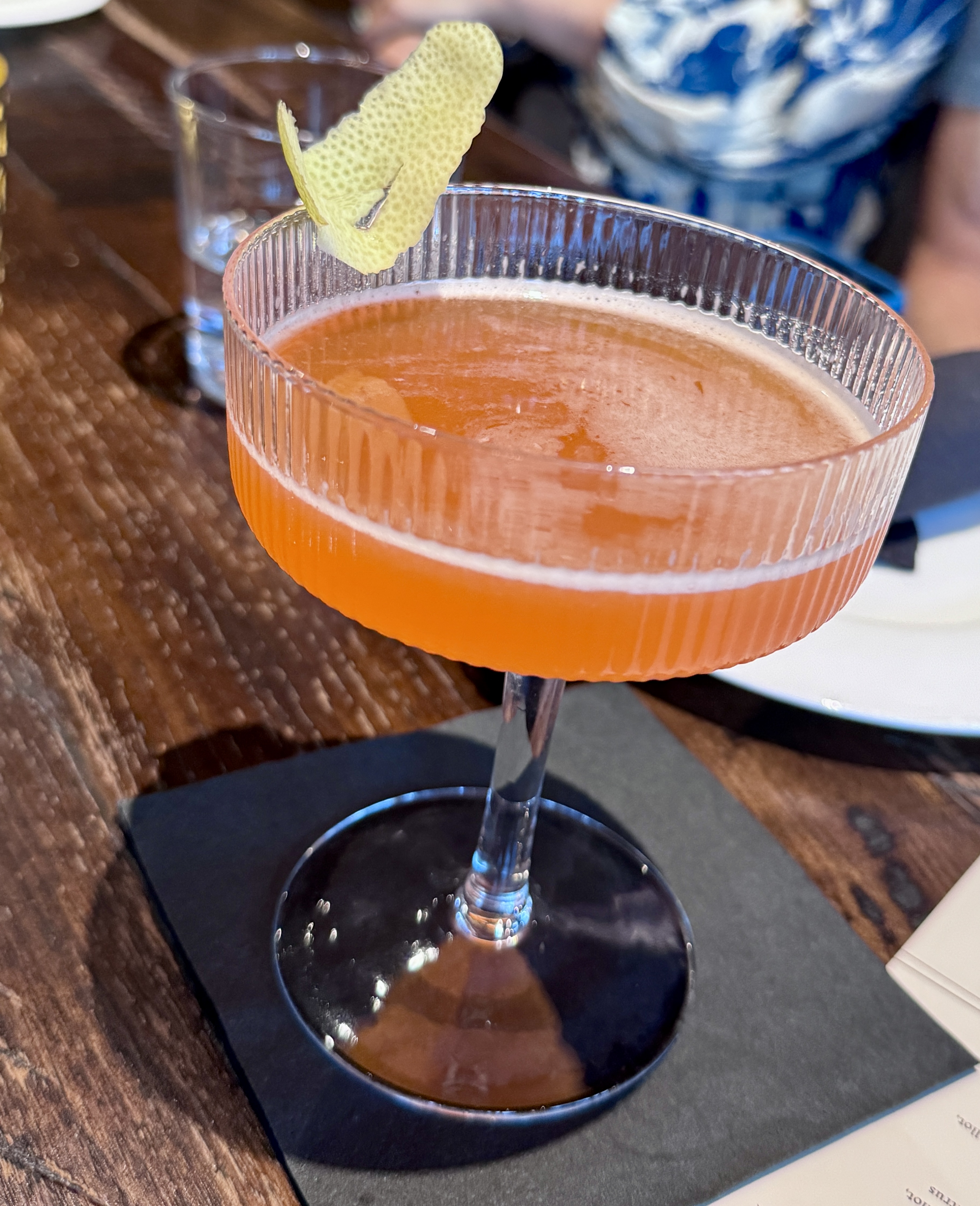 A Paper Plane cocktail in a ribbed coupe glass